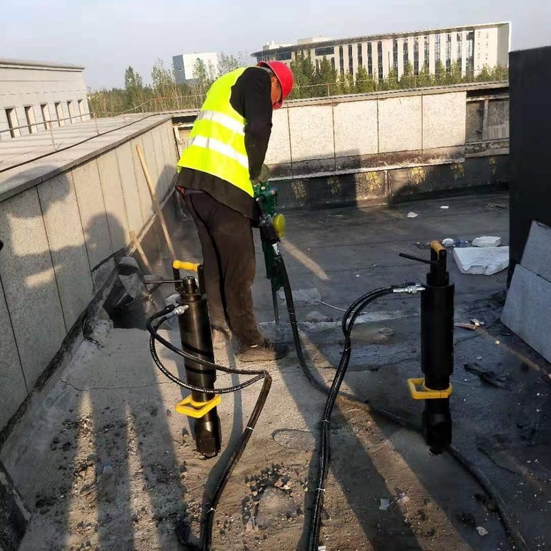 A rock splitter being used in a confined urban construction site